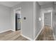 Hallway with wood-look floors and view into the kitchen at 140 Lake Concord Ne Rd # D9, Concord, NC 28025