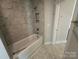Clean bathroom featuring a white bathtub with marble-like tiling and a convenient shower niche at 3229 Mcharney Dr # 30, Harrisburg, NC 28075