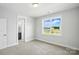 Bright bedroom featuring neutral carpet, a window offering an outside view, and a connected bathroom at 3229 Mcharney Dr # 30, Harrisburg, NC 28075