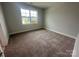 Well-lit bedroom with plush carpeting and a large window offering a view of the surrounding neighborhood at 3229 Mcharney Dr # 30, Harrisburg, NC 28075