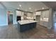 Spacious kitchen featuring a large island, white cabinets, and stainless steel appliances at 3229 Mcharney Dr # 30, Harrisburg, NC 28075
