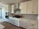 Modern kitchen with white cabinetry, stainless steel appliances, and a mosaic tile backsplash at 3229 Mcharney Dr # 30, Harrisburg, NC 28075