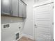 Functional laundry room offering ample storage with gray cabinets and modern utilities at 3229 Mcharney Dr # 30, Harrisburg, NC 28075
