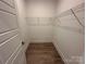 Bright walk-in closet with white shelving, neutral walls, and wood-look floors offer ample storage at 3229 Mcharney Dr # 30, Harrisburg, NC 28075