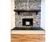Fireplace with stone surround and rustic wood mantel on hardwood floors at 460 27Th Avenue Nw Cir, Hickory, NC 28601