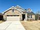 Charming brick home with a two-car garage, stone accents, and a well-manicured lawn at 9653 Liberty Hill Dr, Mint Hill, NC 28227