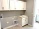 A tidy laundry room with white cabinets and a utility sink at 9653 Liberty Hill Dr, Mint Hill, NC 28227