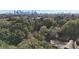 An aerial view of the home surrounded by mature trees and city skyline in the background at 2630 Rose St, Charlotte, NC 28208