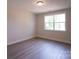 Bedroom featuring wood-look floors, neutral paint and window offering verdant views at 2630 Rose St, Charlotte, NC 28208