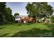 Expansive backyard featuring a well-maintained lawn, mature trees, and a charming outbuilding at 3021 Davis Park Rd, Gastonia, NC 28052