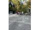 Backyard concrete patio area with grill, chairs, tables, and lush green trees at 3021 Davis Park Rd, Gastonia, NC 28052