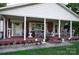 Inviting front porch with brick flooring, decorative columns, and comfortable seating for relaxing outdoors at 3021 Davis Park Rd, Gastonia, NC 28052