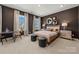 This bedroom boasts dark walls, two windows, carpet, and unique mirrors above the bed at 5216 Mint Harbor Way # 0284, Charlotte, NC 28269