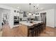 Modern kitchen features an island with seating and white cabinets and black countertop at 5216 Mint Harbor Way # 0284, Charlotte, NC 28269