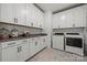 Bright laundry room with white cabinets, gray countertops, patterned floors, and modern washer/dryer at 5216 Mint Harbor Way # 0284, Charlotte, NC 28269