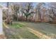 Private backyard with sloping lawn and mature trees at 16 Hill St, York, SC 29745