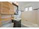 Clean bathroom with a tub, sink, and light wood cabinet at 2423 Vail Ave # A12, Charlotte, NC 28207