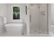 Well-lit bathroom featuring a soaking tub and glass-enclosed shower at 8503 Foxbridge Dr # 16, Matthews, NC 28104