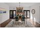 Elegant dining room featuring a brick fireplace, modern chandelier and a dining table for four on a decorative rug at 8503 Foxbridge Dr # 16, Matthews, NC 28104