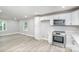 Modern kitchen with white cabinets, stainless steel appliances, and vinyl flooring at 208 Valley St, Stanley, NC 28164