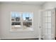 Bright bedroom with wood-look floors, white trim and walls with a window looking out to a home under construction at 112 Rustling Waters Dr, Mooresville, NC 28117