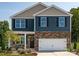 Two-story home with blue and brown siding, white garage door, and landscaping at 3925 Coleman Dr, Charlotte, NC 28215