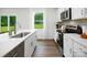 Modern kitchen with white cabinets, stainless steel appliances, and quartz countertops at 3925 Coleman Dr, Charlotte, NC 28215