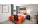 Bedroom with orange bedding and rock wall art at 5211 Reedy Ridge Rd, Charlotte, NC 28215