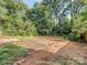 Large backyard area with dirt and overgrown weeds at 2117 Laburnum Ave, Charlotte, NC 28205