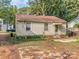 View of the home's backyard with overgrown grass at 2117 Laburnum Ave, Charlotte, NC 28205