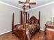 Spacious bedroom with a wooden four-poster bed and hardwood floors at 4730 Rollins Pointe Dr, Monroe, NC 28110