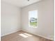 Bright and airy bedroom with wood-look flooring and a large window offering backyard views at 3607 Clover Valley Dr, Gastonia, NC 28052