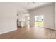 Open-concept living room with wood-look flooring, sliding glass doors, and a view of the kitchen island at 3607 Clover Valley Dr, Gastonia, NC 28052