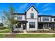 Charming two-story home featuring gray siding, black trim, a covered porch, and landscaped front yard at 97 Seven Oaks Lndg, Belmont, NC 28012
