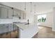 Well-lit kitchen boasts gray cabinets, white countertops, a center island with sink, and views from the window at 97 Seven Oaks Lndg, Belmont, NC 28012