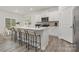 Modern kitchen features white cabinets, stainless steel appliances, and a spacious island with bar seating at 104 Rustling Waters Dr, Mooresville, NC 28117