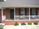 Inviting front porch with white railing, brick steps, and decorative hanging flower baskets at 3905 Autumn Wood Dr # 28, Monroe, NC 28112