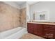 Bathroom with a bathtub, a vanity with a large mirror, and tiled walls at 5942 Carmel Rd, Charlotte, NC 28226