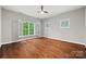 Bright bedroom featuring hardwood floors and large windows with plantation shutters at 5942 Carmel Rd, Charlotte, NC 28226