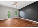 Bedroom with hardwood floors, a door to a balcony, and a dark accent wall at 5942 Carmel Rd, Charlotte, NC 28226