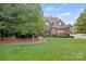 Stone and brick two-story house with a gabled roof, landscaping, and a large lawn at 5942 Carmel Rd, Charlotte, NC 28226