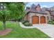 Two-car garage with wood doors and landscaping at 5942 Carmel Rd, Charlotte, NC 28226