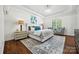 Bright bedroom with hardwood floors, a sitting area, and plantation shutters at 5942 Carmel Rd, Charlotte, NC 28226