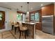 Basement bar area with seating, stone backsplash, pendant lights, and a stainless steel refrigerator at 10310 Wildlife Rd, Charlotte, NC 28278