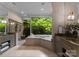 Bathroom showcasing soaking tub, dual vanities, and walk-in shower with stone surround at 10310 Wildlife Rd, Charlotte, NC 28278