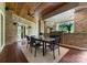 Cozy outdoor patio with a wooden ceiling, stone accents, fireplace, and dining area for relaxing gatherings at 10310 Wildlife Rd, Charlotte, NC 28278