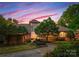 Beautiful single-Gathering home with manicured landscaping, stone accents, and lush greenery in a serene neighborhood at 10310 Wildlife Rd, Charlotte, NC 28278