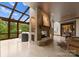 Cozy living room with a stone fireplace, skylight, and walls of large windows at 10310 Wildlife Rd, Charlotte, NC 28278