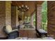 Covered outdoor living space with a hot tub and stone pillars, ideal for relaxation and enjoying nature at 10310 Wildlife Rd, Charlotte, NC 28278