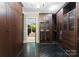 Spacious walk-in closet featuring custom built-ins with glass doors and dark wood flooring at 10310 Wildlife Rd, Charlotte, NC 28278